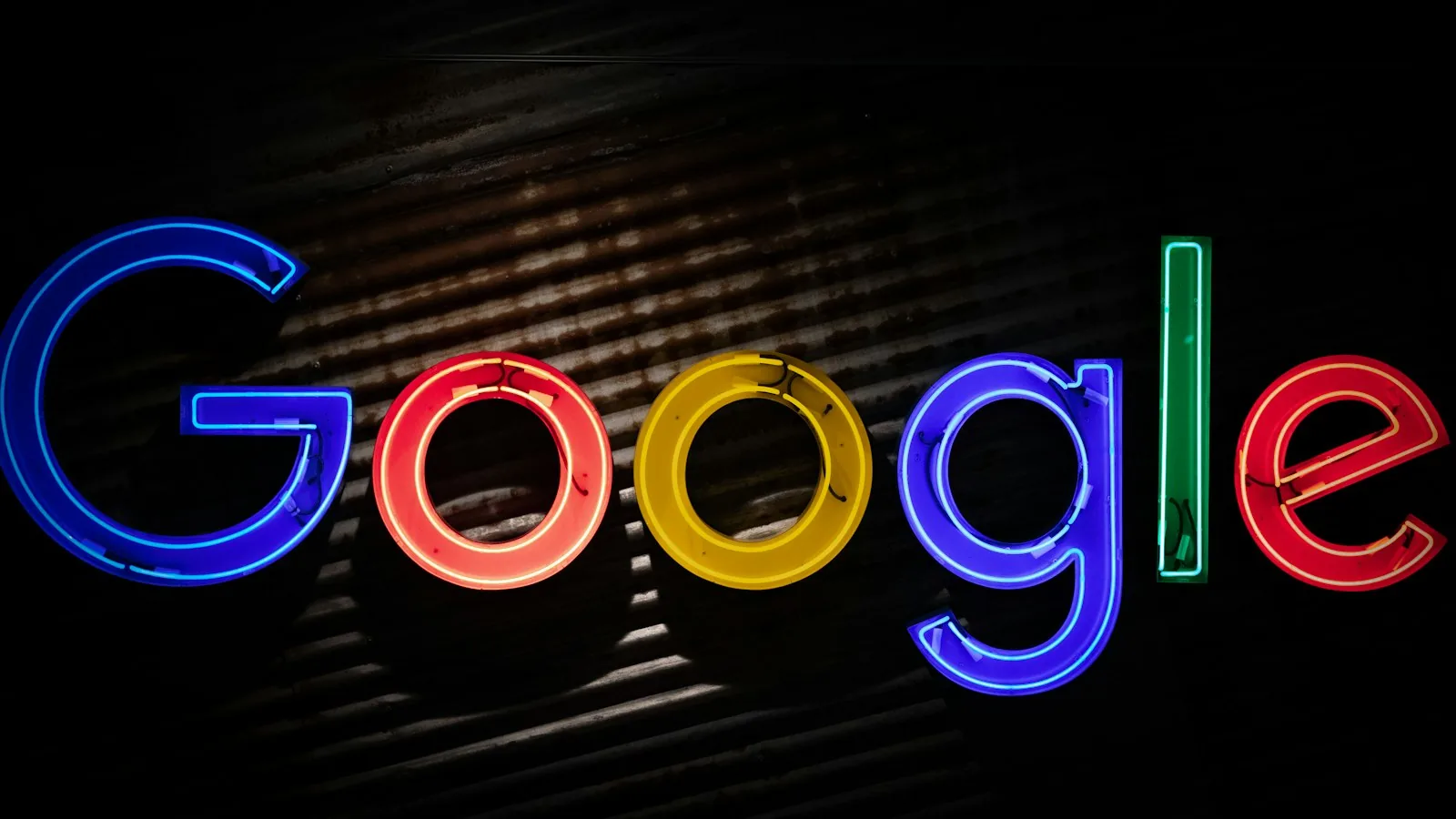 The Google logo in neon letters on a dark wall