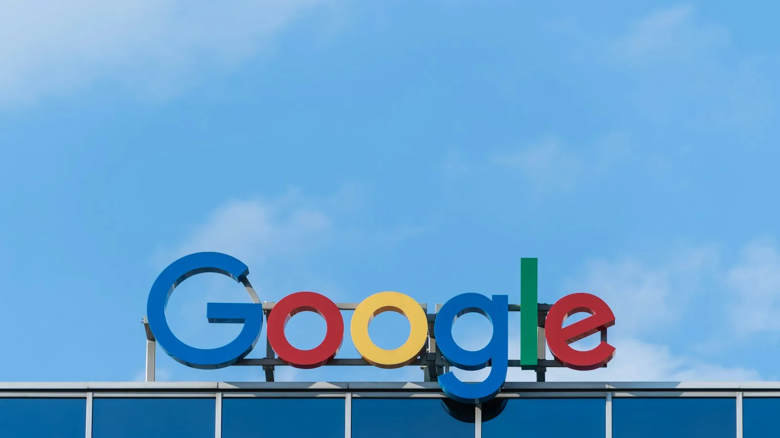 The Google sign on the facade of an office building against a blue sky
